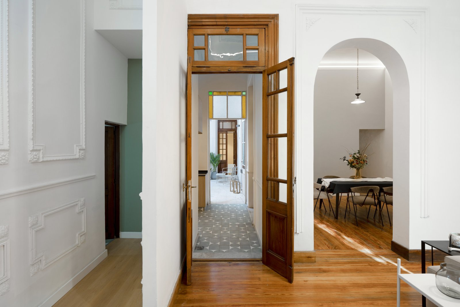 Pasillo interior con detalles clásicos y acceso a comedor — proyecto Casa Gainza, por Estudio Plats, en Caballito